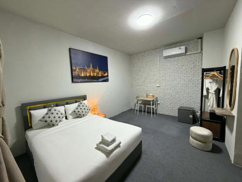 a bedroom with a large white bed and a table at Phuket gateway inn in Kathu