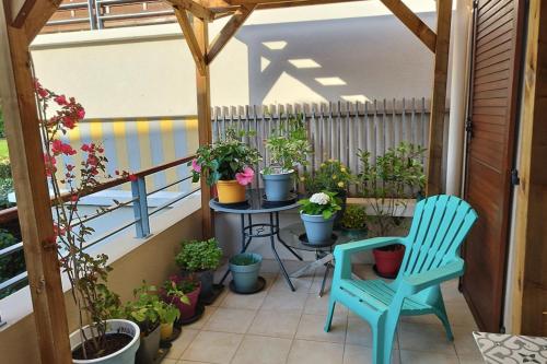 a balcony with a table and chairs and potted plants at Spacious appartment with terrace and shared pool in Fréjus