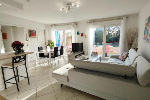 a living room with a couch and a table at Spacious appartment with terrace and shared pool in Fréjus