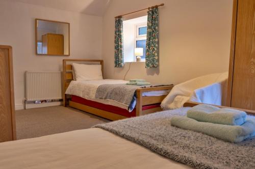 a small bedroom with two beds and a mirror at Finest Retreats - East Bank in Matlock