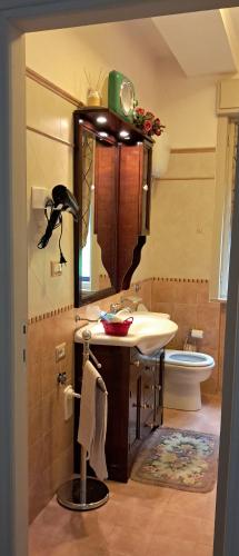 a bathroom with a sink and a mirror and a toilet at Orlando House 1975 in Montecchio