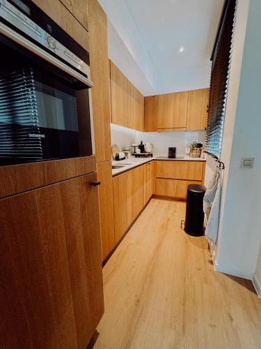 a kitchen with wooden cabinets and a large appliance at la MERéMOI - Duplex Knokke with balcony and free parking in Knokke-Heist
