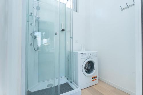 a washing machine in a bathroom with a glass shower at Stay Bergamo Centro in Bergamo