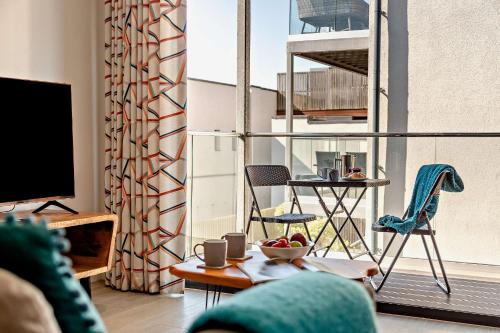 a living room with a balcony with a table and chairs at 8 Putsborough - Luxury Apartment at Byron Woolacombe, only 4 minute walk to Woolacombe Beach! in Woolacombe