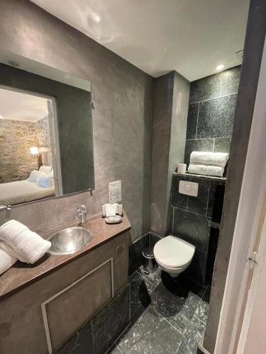 a bathroom with a sink and a toilet and a mirror at Hotel B Lodge in Saint-Tropez