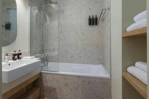 a bathroom with a tub and a sink and a shower at Residence Inn by Marriott Lille in Lille