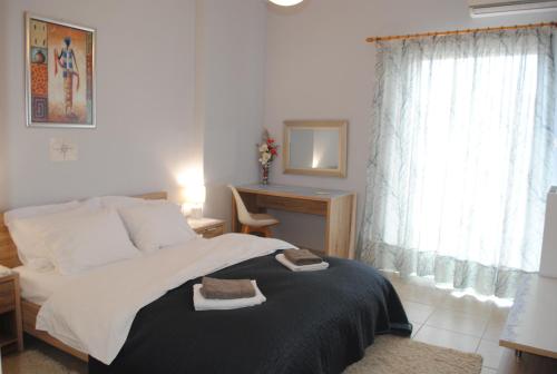 a bedroom with a bed and a desk and a window at Sweet Suites in Amalias