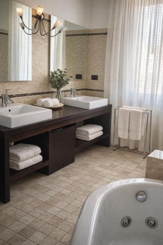 a bathroom with two sinks and a bath tub at Sunshine Luxury Apartment - spacious house - Lake View - Pool in Padenghe sul Garda