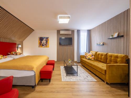 a hotel room with a bed and a couch at Hotel Benica in Benešov