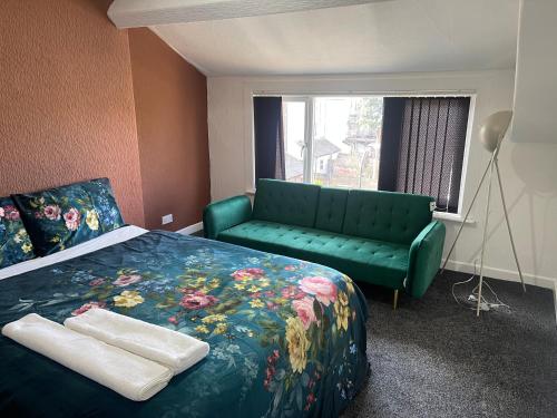 a bedroom with a bed and a green couch at Princess Shahzadi in Manchester