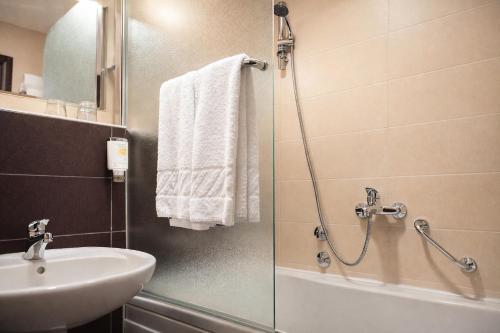 a bathroom with a shower and a sink and a shower at Nobel Inn Hotel in Belgrade