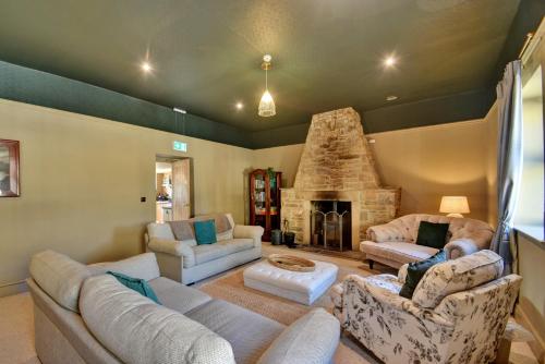 a living room with couches and a stone fireplace at Finest Retreats - Blackton Farmhouse in Barnard Castle