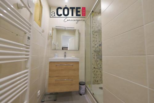 un baño con lavabo, espejo y ducha en Le nid bleu, en Sausset-les-Pins