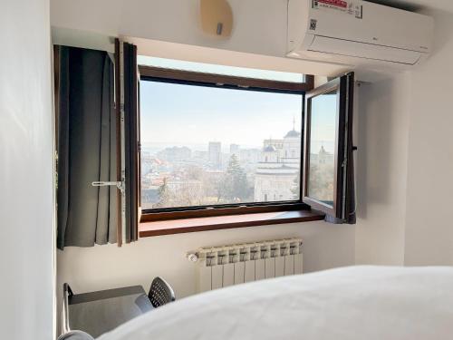 a bedroom with a window with a view of the city at Central Apartments' Privat-Sauna free Parking AmurResidence FamilyConcept in Iaşi