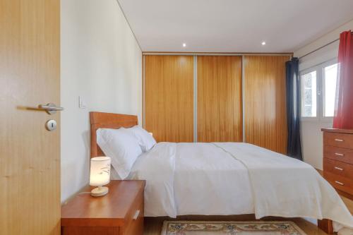 a bedroom with a bed and a table with a lamp at Casa das Agras in Souto