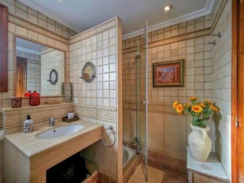 a bathroom with a sink and a vase of flowers at Beachfront in Denia Alicante in Denia