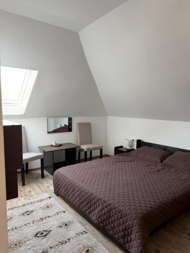 a bedroom with a bed and a table and a mirror at Alexia Agropension in Pui