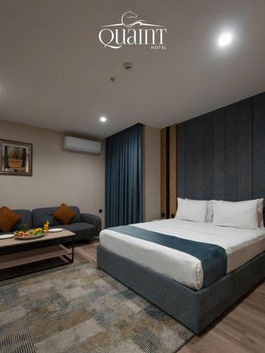 a bedroom with a large bed and a couch at Quaint Hotel Erbil in Erbil