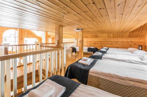 a bedroom with two beds in a wooden cabin at Päijänteen Helmi 1 in Jämsä
