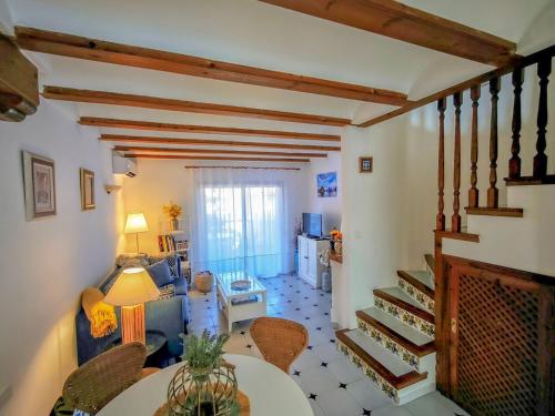 a living room with a staircase and a table and chairs at Beachfront in Denia Alicante in Denia