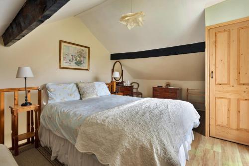 a bedroom with a bed with a white comforter at Finest Retreats - Vine Barn in Bellerby