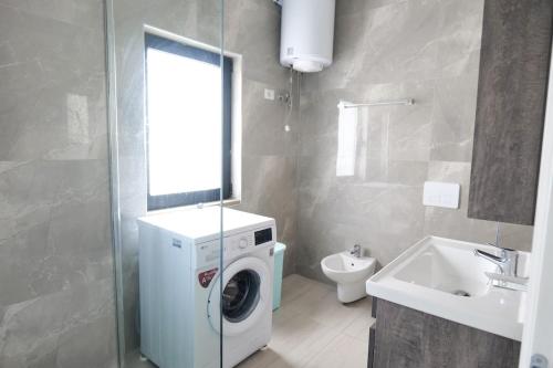 a bathroom with a washing machine and a sink at Olive Qerret in Golem