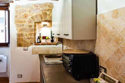 a kitchen with a toaster on a counter with a stone wall at Casa Vacanze Todi in Todi