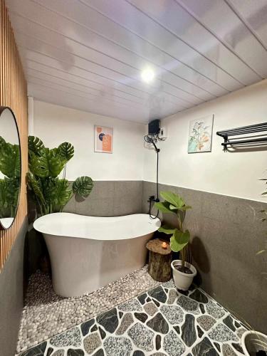 a bathroom with a bath tub and plants in it at Maria Staycation House in Davao City