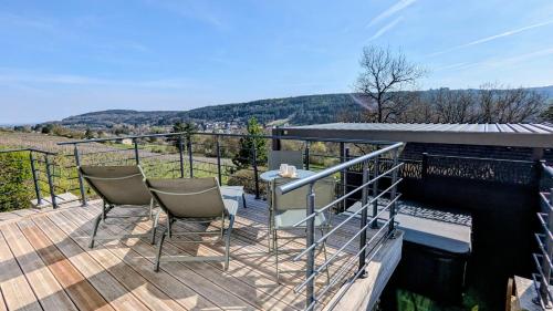 a wooden deck with chairs and a table on it at Savigny Vineyard View & SPA in Savigny-lès-Beaune