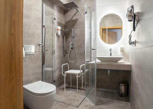 a bathroom with a shower and a toilet and a sink at Hotel Zawisza in Bydgoszcz