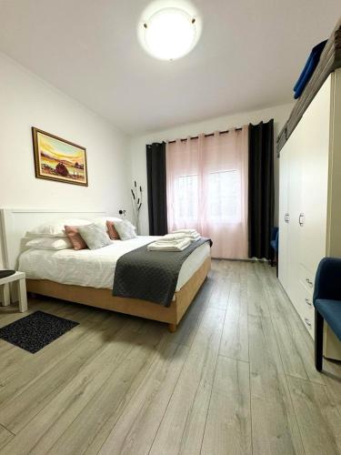 a bedroom with a large bed with a wooden floor at Apartment Ambretta in Savudrija