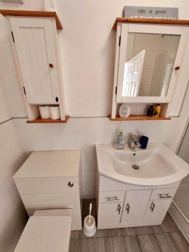a small bathroom with a sink and a mirror at Harbour View Saundersfoot in Saundersfoot