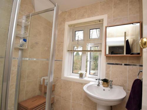 a bathroom with a sink and a shower with a window at 4 Bed in Swanage oc-dc046 in Studland
