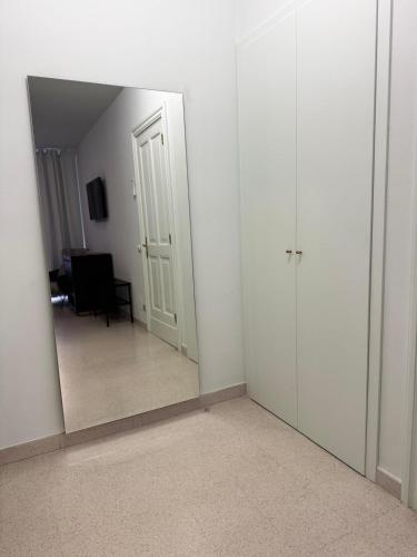 an empty room with a mirror and a room with a chair at Appartamento Rosa Rosa' in Porto SantʼElpidio