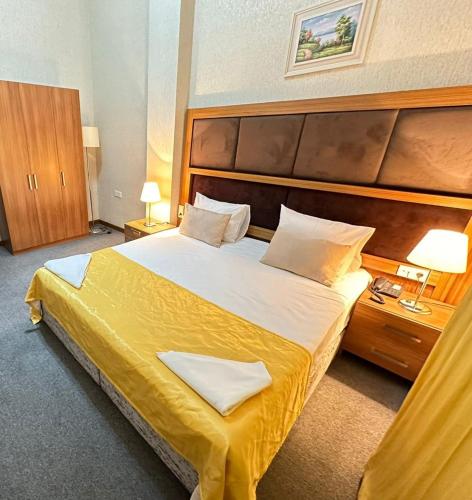 a hotel room with a large bed with yellow sheets at Turkiye Hotel - Free Massage - Free Swimming Pool in Baku