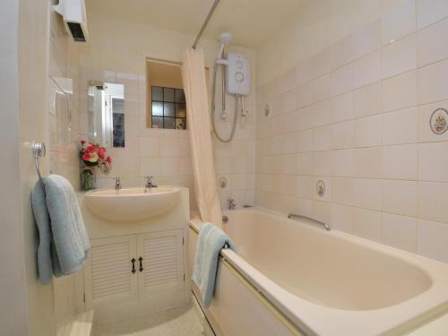 a bathroom with a tub and a sink and a bath tub at 1 Bed in Bridport oc-dc085 in Loders