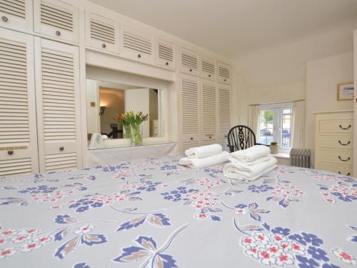 a bedroom with a large bed with a blue flower pattern at 1 Bed in Bridport oc-dc085 in Loders