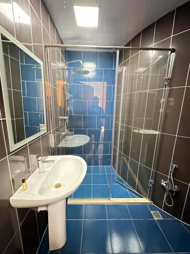 a blue tiled bathroom with a sink and a shower at Turkiye Hotel - Free Massage - Free Swimming Pool in Baku