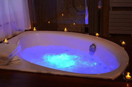 a bath tub filled with blue water with candles at Bienvenue chez Sylvie in Lyon