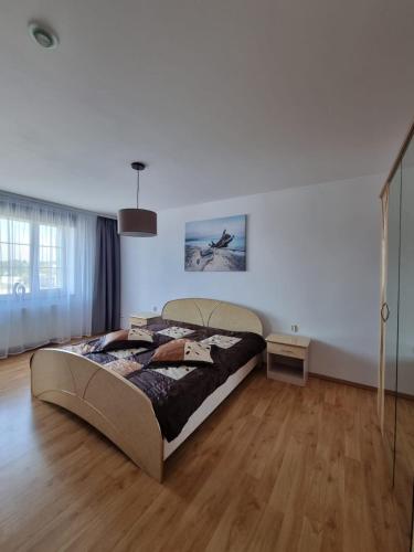 a bedroom with a large bed and a wooden floor at Darłowska 49A in Dąbki