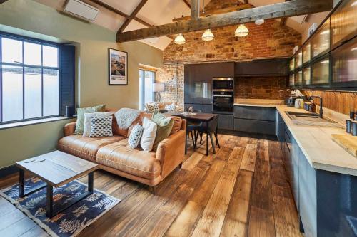 a living room with a couch and a kitchen at Host & Stay - Kingbridge Forge in Lanercost