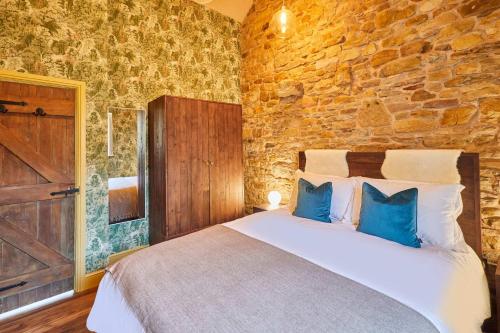 a bedroom with a large bed with blue pillows at Host & Stay - Kingbridge Forge in Lanercost