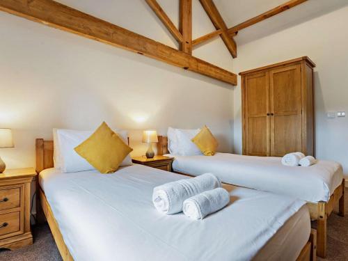 two twin beds in a room with wooden ceilings at 3 Bed in Malton oc-75898 in Amotherby