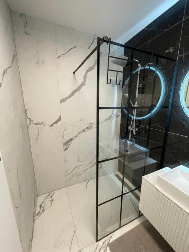 a bathroom with a glass shower and a sink at Apartmán beige Bardejovské Kúpele in Bardejov