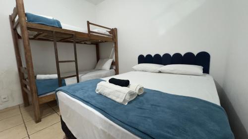 a bedroom with two bunk beds and towels on a bed at Escadaria Vila Rica Pousada & Hostel in Ouro Preto