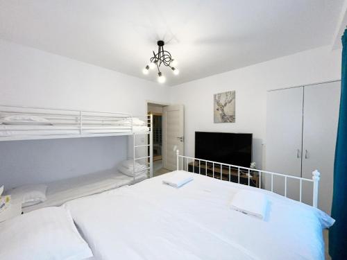 a bedroom with a large white bed and a chandelier at AmurResidence 64 Sauna Parking Barbeque in Iaşi