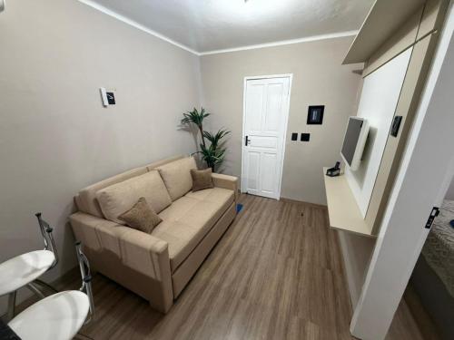 a living room with a couch and a tv at Casa aconchegante em Olaria in Nova Friburgo