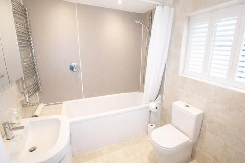 ein Badezimmer mit weißer Toilette, Badewanne und Waschbecken in der Unterkunft Brookside, Hawkshead with garden and parking in popular village in Hawkshead