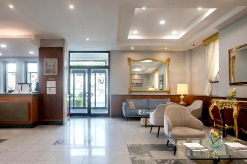 a lobby with a couch and a mirror at American Hotel in Pozzuoli