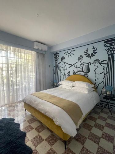 a bedroom with a bed and a wall with drawings on it at Villa Chamoun in Al Wādī